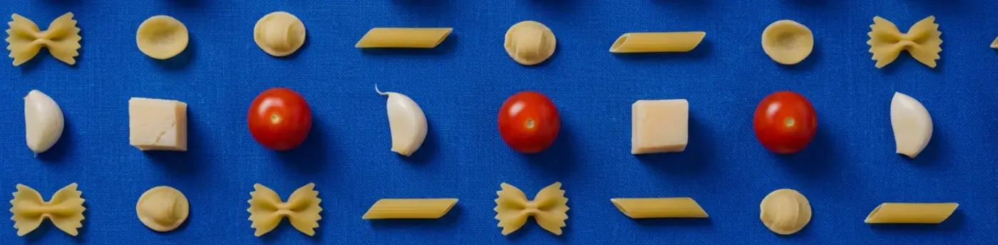 Tomates, ajo y albahaca ordenados en retícula sobre lino azul